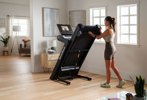 Trainer adjusting a treadmill